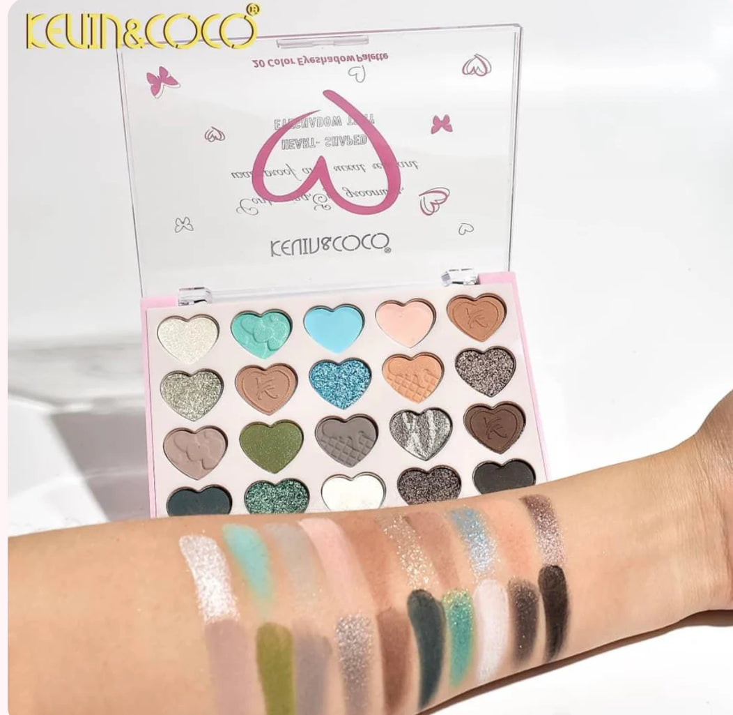 Makeup palette with heart-shaped colors and swatches on a arm, branded 'Kevin & Coco'.
