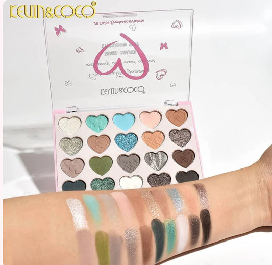 Makeup palette with heart-shaped colors and swatches on a arm, branded 'Kevin & Coco'.