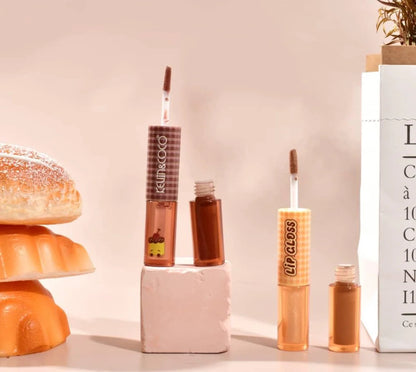 KEVIN & COCO Lip gloss products with a decorative stand on a light background