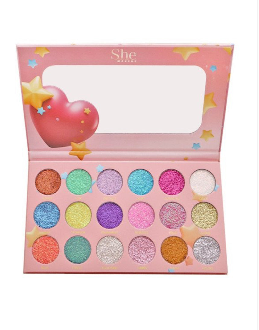 Colorful eyeshadow palette with 'She' branding on a white background